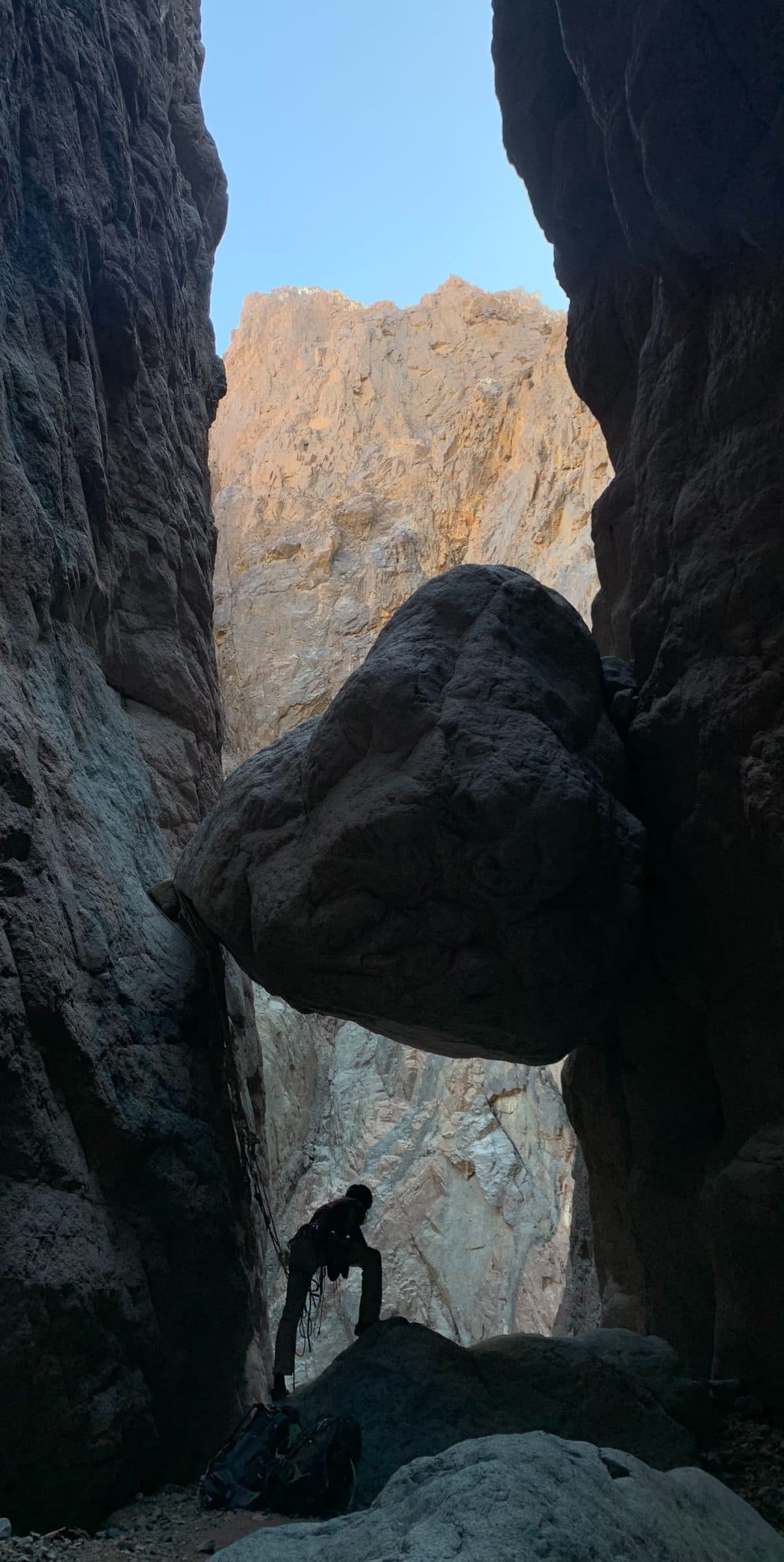 Climber under a chockstone in Abu Khsheib Canyon